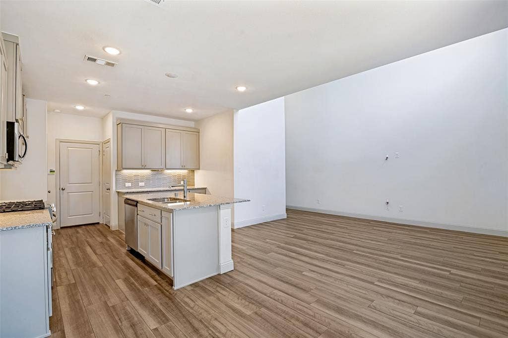 1006 Emil Place, Allen, TX 75013 Kitchen island with built-in sink, stainless steel dishwasher, and bar seating