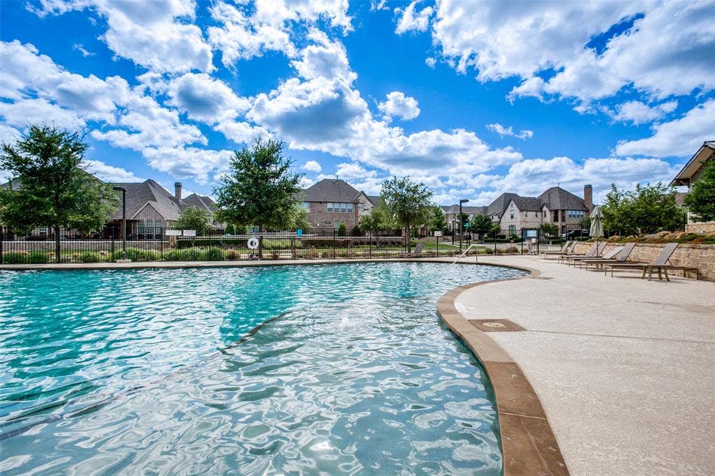 1006 Emil Place, Allen, TX 75013 Curved swimming pool with a stone coping and a concrete surround