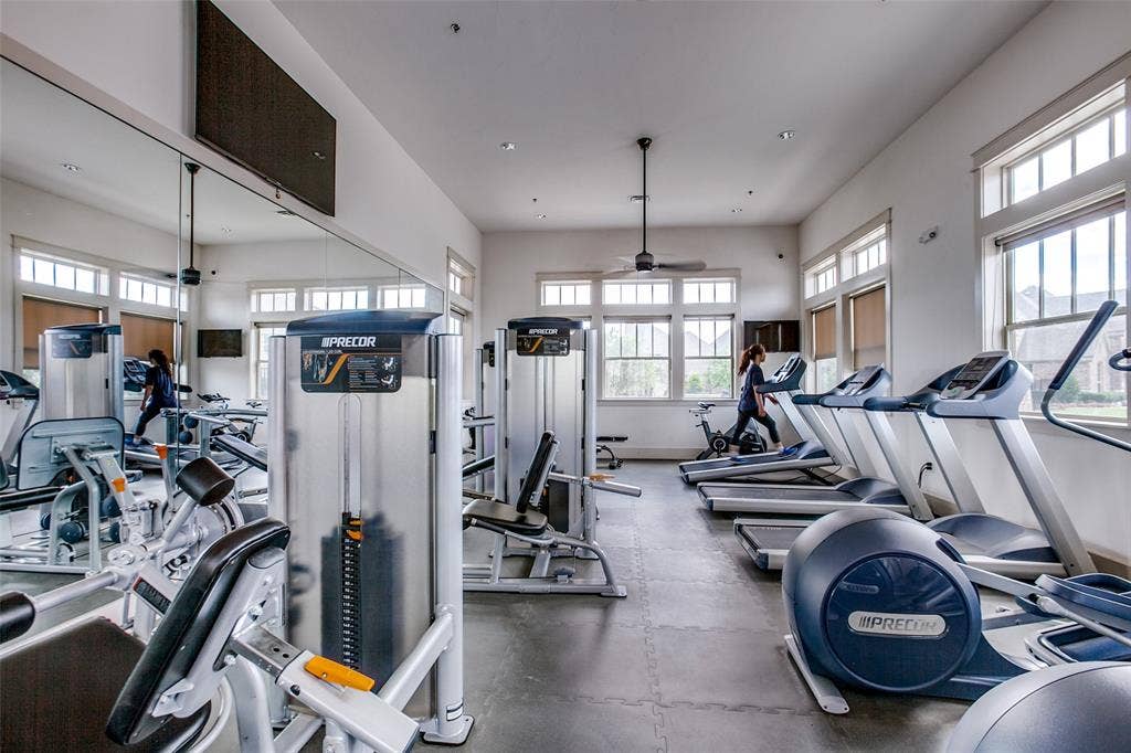 1006 Emil Place, Allen, TX 75013 Fitness center featuring a mirrored wall, ample natural light from multiple windows, ceiling fan, and various exercise machines