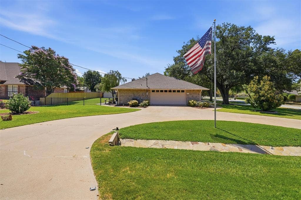 5711 Cortez Drive, Granbury, TX 76049 Stone veneer siding with an attached two-car garage