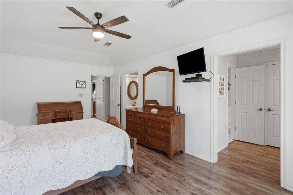 5711 Cortez Drive, Granbury, TX 76049 Large primary bedroom featuring wood-finish flooring, a vaulted ceiling, and a ceiling fan