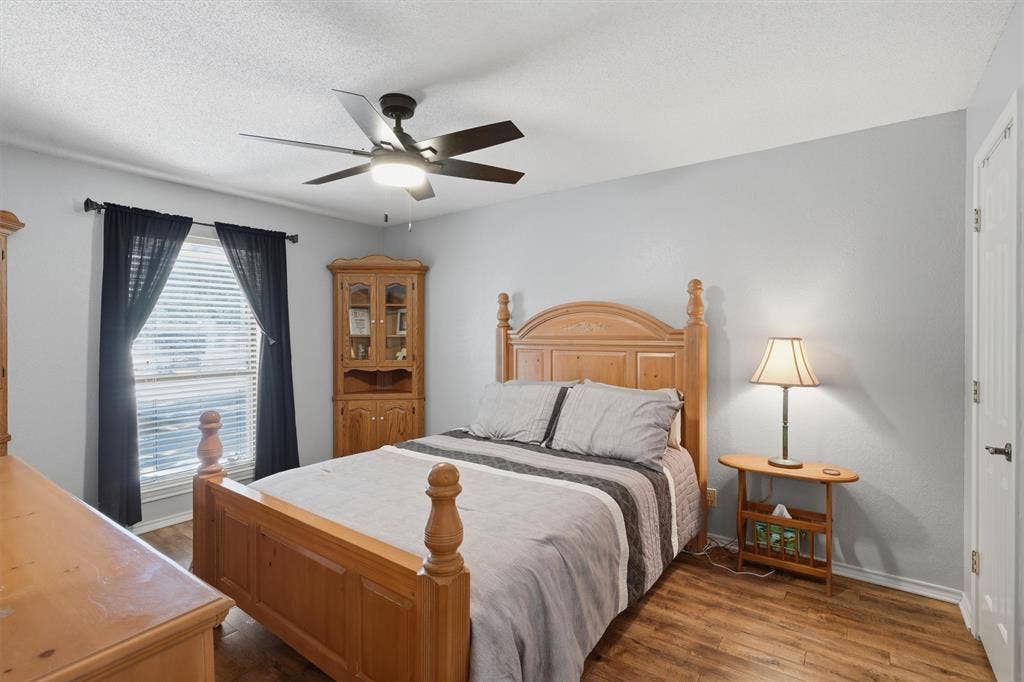 5711 Cortez Drive, Granbury, TX 76049 Bedroom featuring wood-finish flooring, a ceiling fan with integrated lighting, and a white paneled door