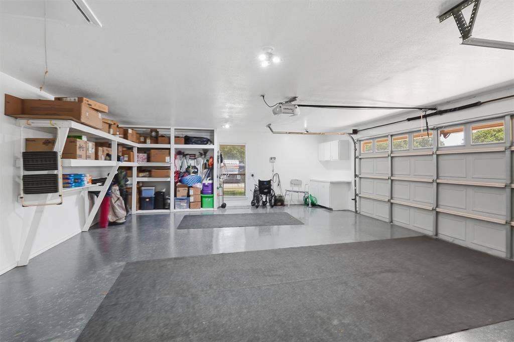 5711 Cortez Drive, Granbury, TX 76049 Extra large garage with expoxy floors, workbench and built in shelves