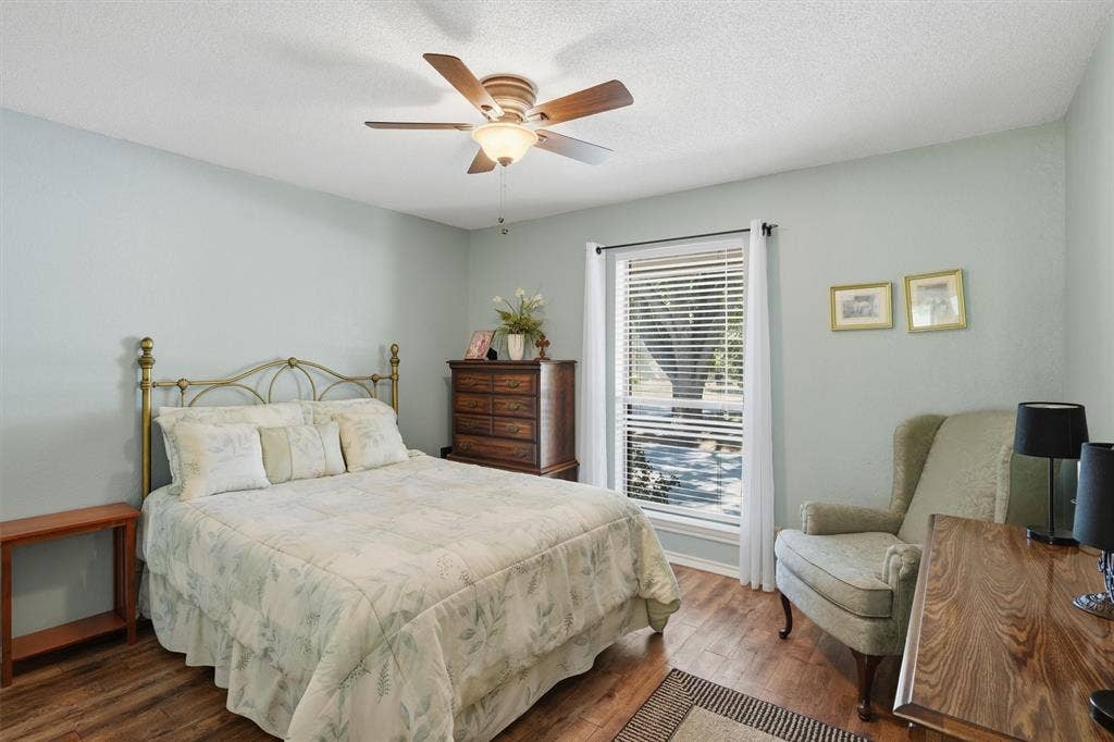 5711 Cortez Drive, Granbury, TX 76049 Interior space featuring wood-finish flooring, a ceiling fan with integrated lighting, and a large window with blinds and sheer curtains