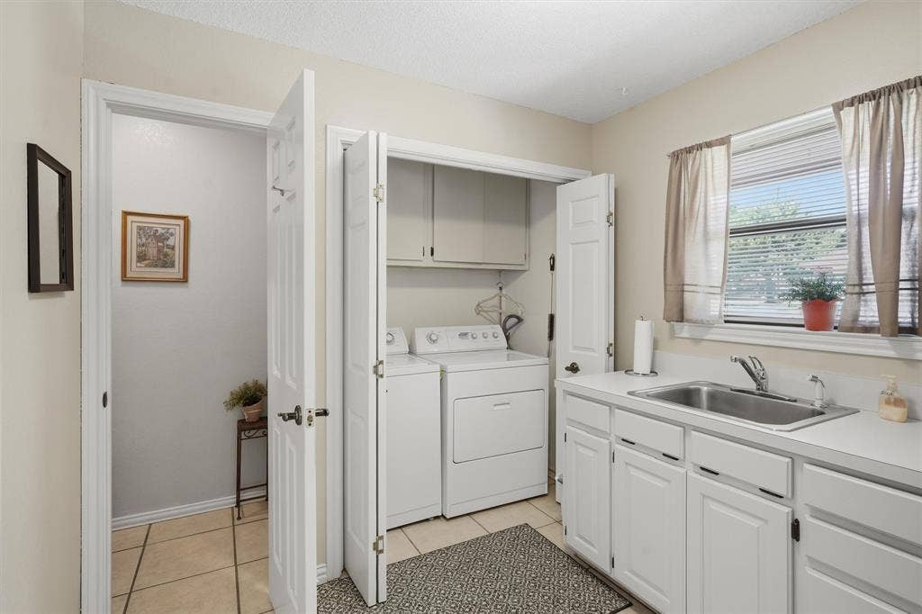 5711 Cortez Drive, Granbury, TX 76049 Utility area featuring a stainless steel sink, Pantry, white cabinetry, and a window with blinds