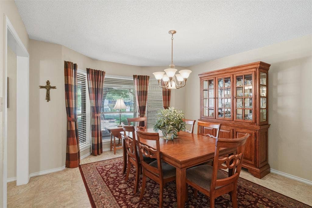 5711 Cortez Drive, Granbury, TX 76049 Bay window with blinds, overhead chandelier lighting, and a neutral color palette