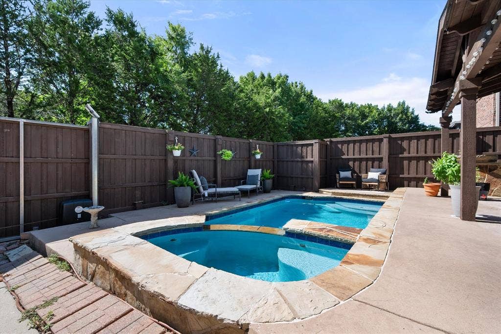 12032 Terrazzo Lane, Frisco, TX 75035 Private fence surrounds the swimming pool with an integrated spa, stone coping and concrete patio!