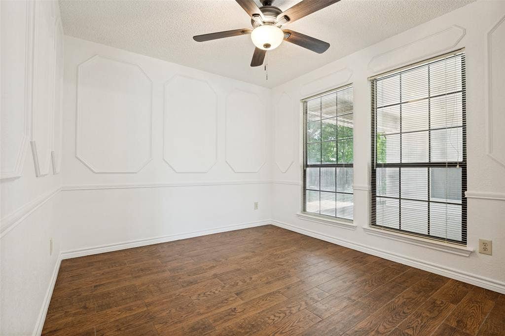 131 Honey Tree Lane, DeSoto, TX 75115 Room featuring wood-finish flooring, decorative wall molding, and two large multi-pane windows