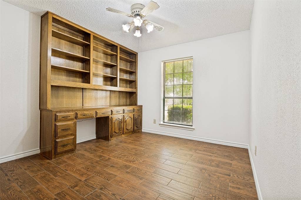 131 Honey Tree Lane, DeSoto, TX 75115 Room featuring a built-in wood-finish shelving unit with integrated desk and cabinetry