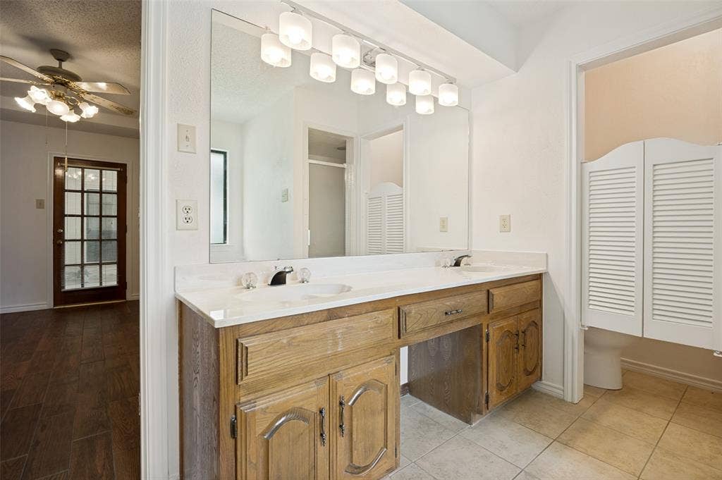 131 Honey Tree Lane, DeSoto, TX 75115 Double vanity with integrated sinks, white countertop, and wood-finish cabinetry
