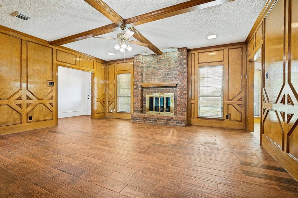 131 Honey Tree Lane, DeSoto, TX 75115 Spacious room featuring wood-finish flooring, wood paneling, and exposed ceiling beams