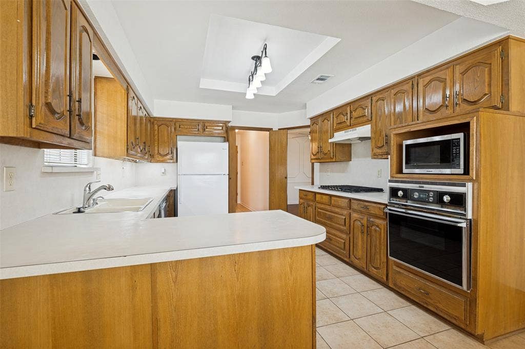 131 Honey Tree Lane, DeSoto, TX 75115 Kitchen with wood-finish cabinetry, integrated built-in oven, and a built-in microwave