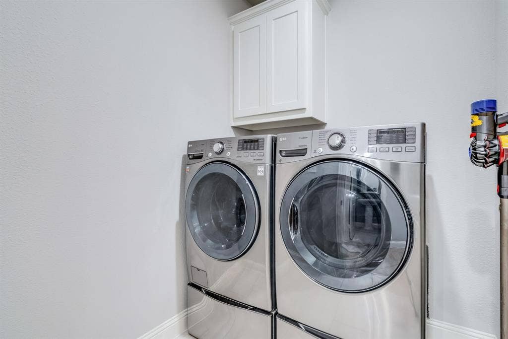 Laundry area featuring upper cabinetry and wall-mounted appliances