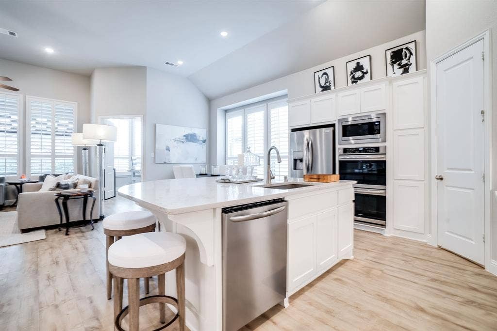 Bright kitchen island with a white countertop and stainless steel sink