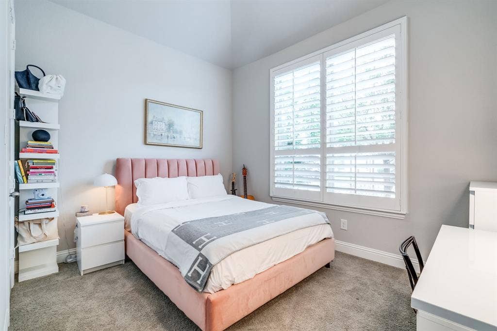 Bedroom featuring plush carpeting, white walls, and a vaulted ceiling