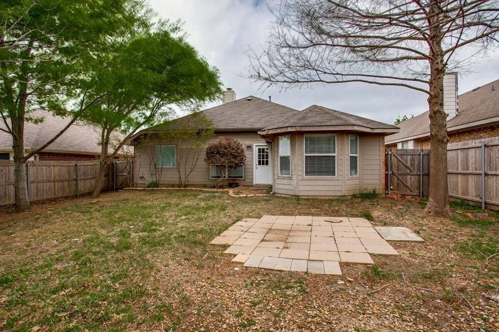 9213 Norfolk Lane, McKinney, TX 75071 Expansive backyard featuring a stone paver patio, mature trees, and privacy fencing