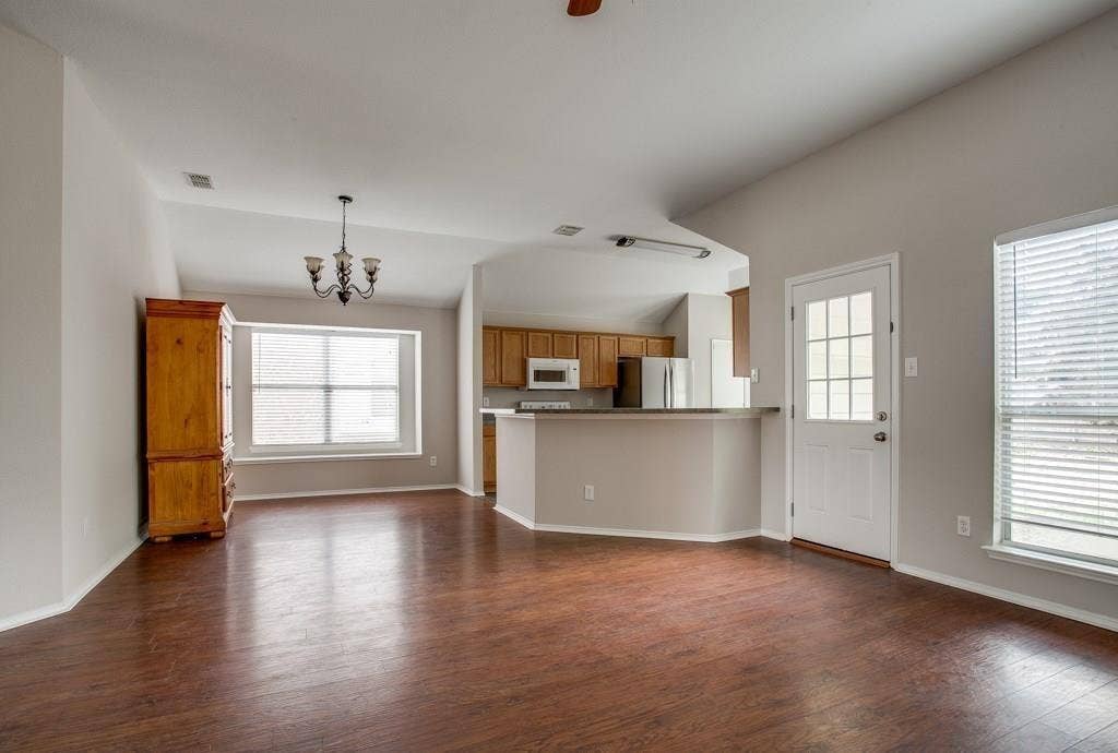 9213 Norfolk Lane, McKinney, TX 75071 Spacious living area featuring rich wood-finish flooring and vaulted ceilings