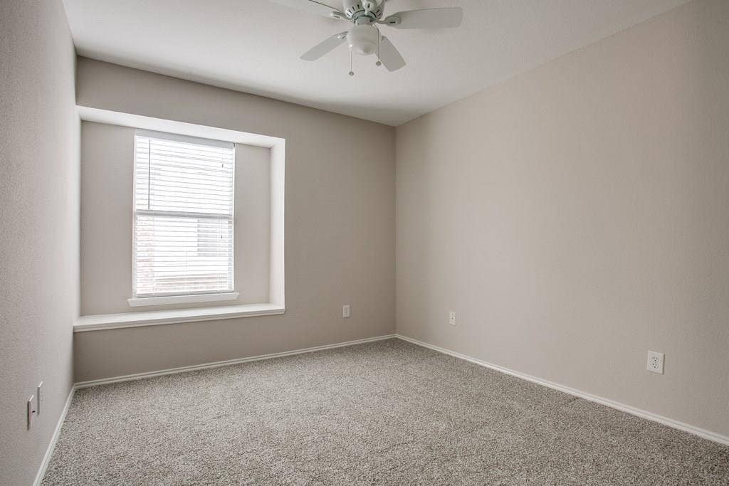 9213 Norfolk Lane, McKinney, TX 75071 Spacious room featuring neutral paint, light gray carpeting, a window with horizontal blinds, and a ceiling fan