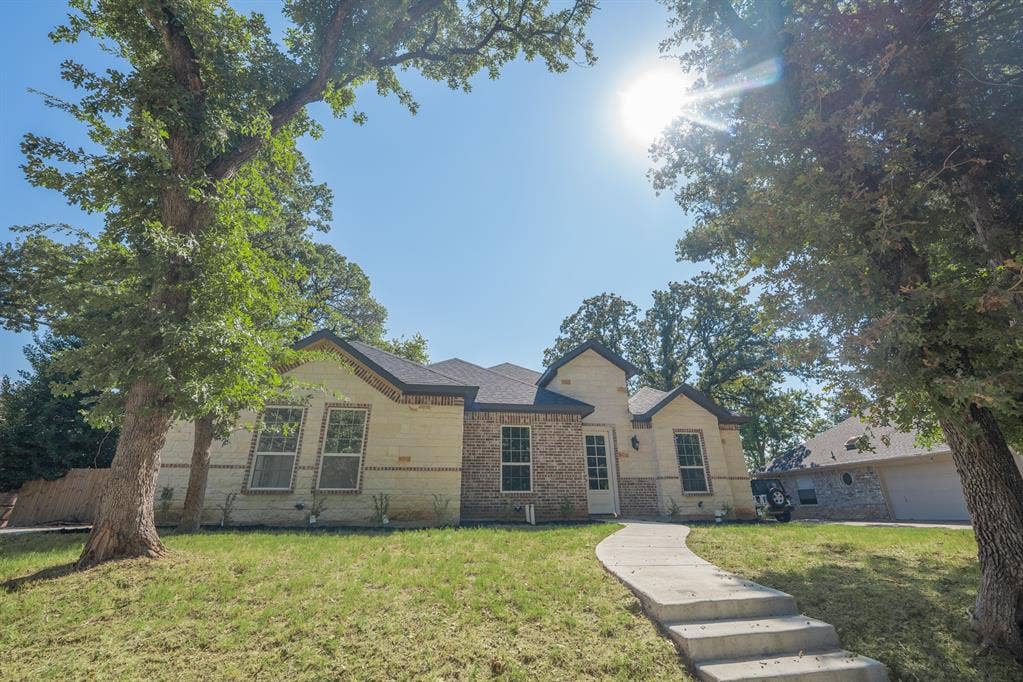 1408 Spinnaker Lane, Azle, TX 76020 Exterior featuring a brick and siding facade with prominent gables and a dark shingle roof