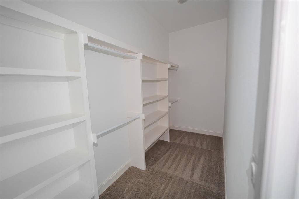 1408 Spinnaker Lane, Azle, TX 76020 Walk-in closet featuring built-in shelving, hanging rods, and carpet flooring