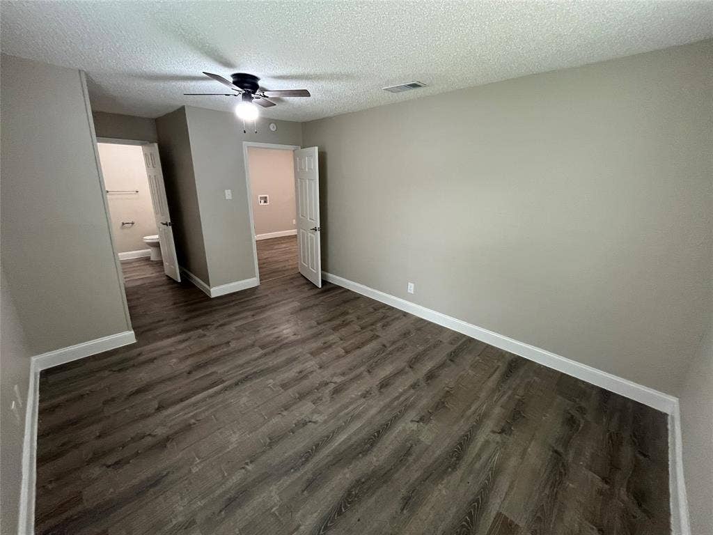 719 Fairwood Drive, Dallas, TX 75232 Spacious room featuring wood-finish flooring, light neutral wall paint, and white baseboards