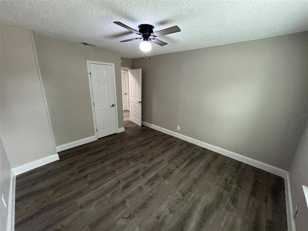 719 Fairwood Drive, Dallas, TX 75232 Spacious room featuring wood-finish flooring, neutral wall paint, white baseboards, and a ceiling fan with integrated lighting