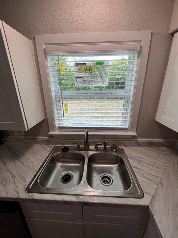 719 Fairwood Drive, Dallas, TX 75232 Stainless steel double basin sink with an arched faucet set into a marble-look laminate countertop