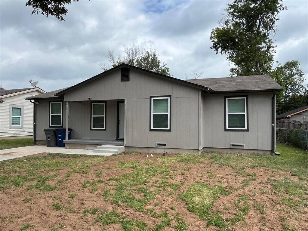 719 Fairwood Drive, Dallas, TX 75232 Single-story residence featuring light gray siding with dark trim, a covered front porch, and a concrete driveway