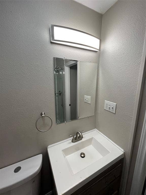 719 Fairwood Drive, Dallas, TX 75232 Bathroom vanity featuring an integrated sink, brushed nickel faucet, and a wood-finish cabinet with dark hardware