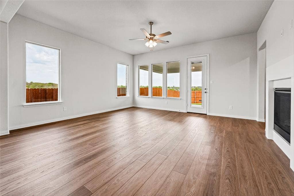 10008 Birchpoint Drive, Fort Worth, TX 76108 Spacious living area featuring wood-finish flooring, multiple windows, a ceiling fan, and a built-in fireplace