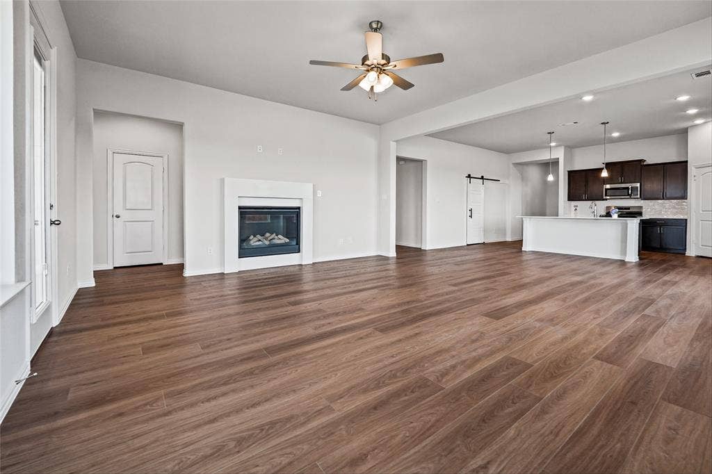 10008 Birchpoint Drive, Fort Worth, TX 76108 Wood-finish flooring throughout, featuring a modern fireplace with white surround, a ceiling fan, and recessed lighting