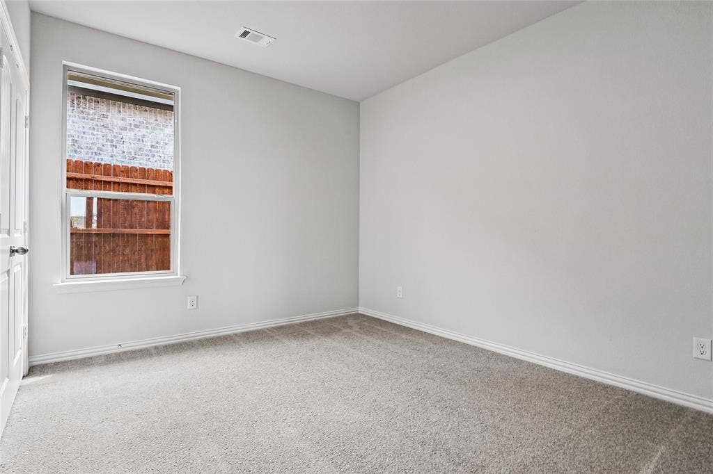 10008 Birchpoint Drive, Fort Worth, TX 76108 Neutral-toned wall finishes, light-colored carpet, white trim, and a prominent window