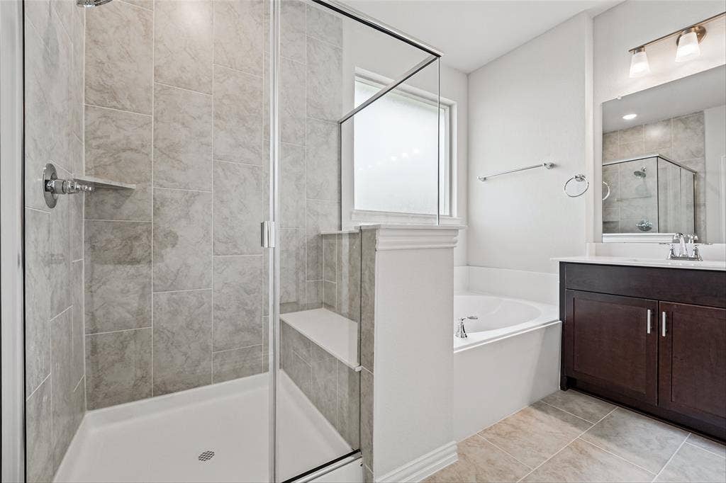 10008 Birchpoint Drive, Fort Worth, TX 76108 Glass-enclosed shower with a built-in bench and tiled walls