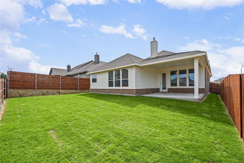 10008 Birchpoint Drive, Fort Worth, TX 76108 Expansive lawn with a covered patio, brick and siding exterior, and wood fencing