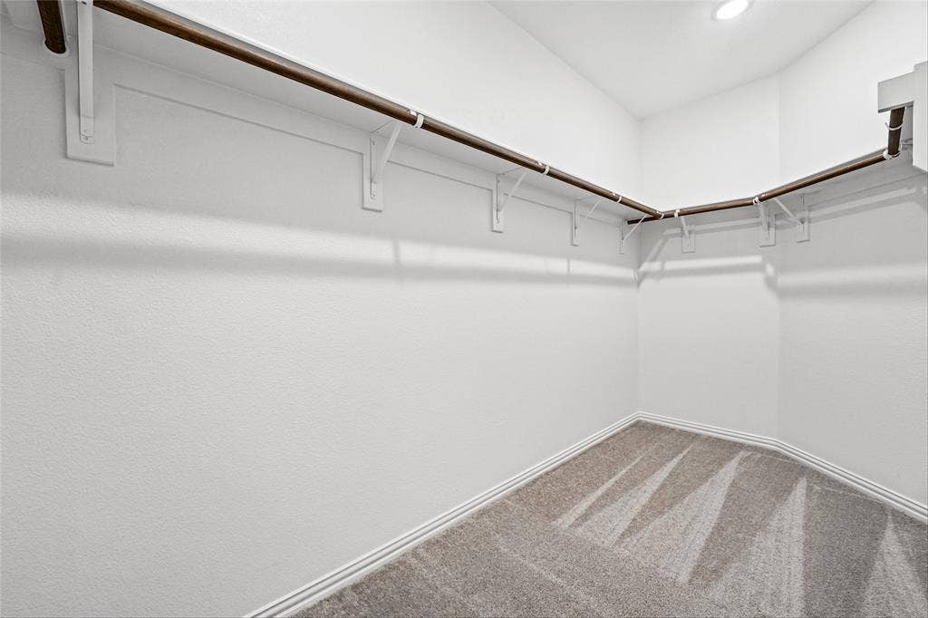 10008 Birchpoint Drive, Fort Worth, TX 76108 Walk-in closet with integrated hanging rods, white walls, and carpet flooring