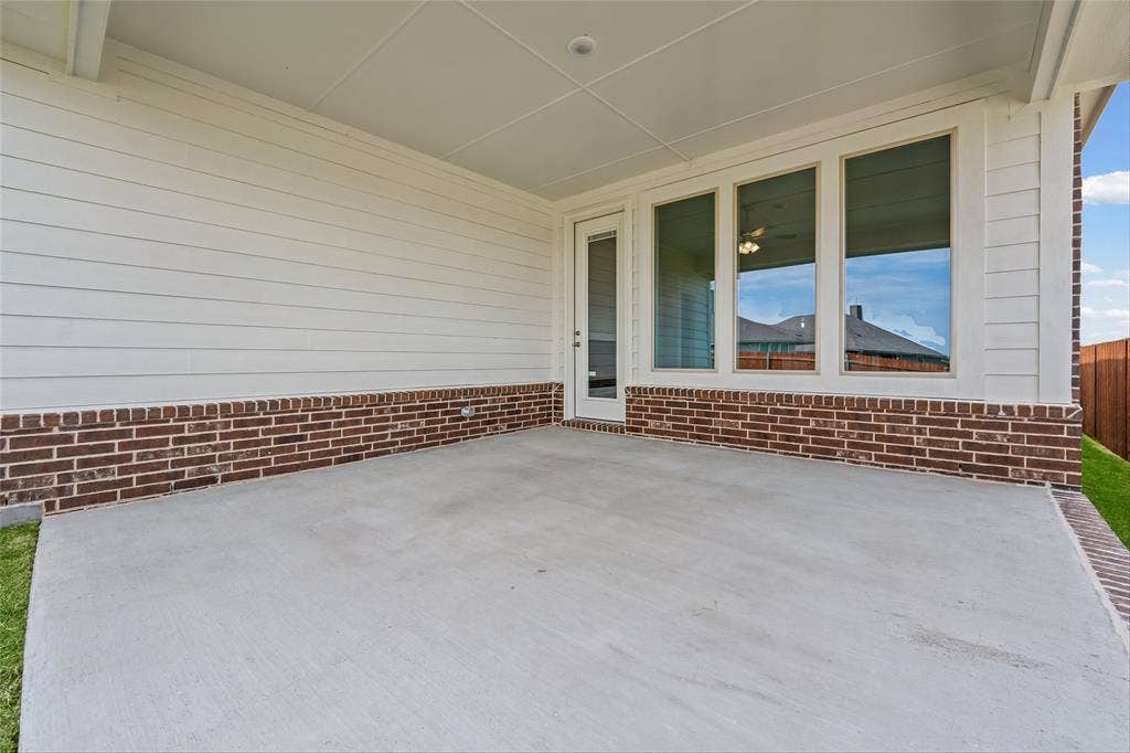 10008 Birchpoint Drive, Fort Worth, TX 76108 Covered patio featuring a concrete slab, brick detailing, and multiple windows