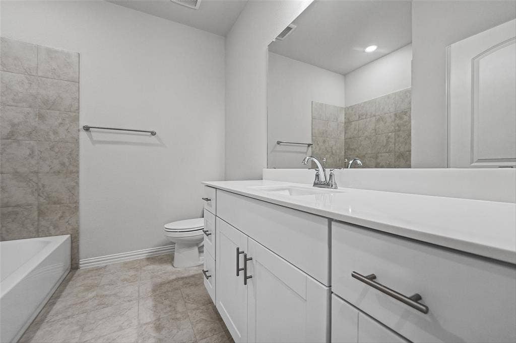 10004 Birchpoint Drive, Fort Worth, TX 76108 White vanity with an integrated sink, polished chrome faucet, and gray tile flooring
