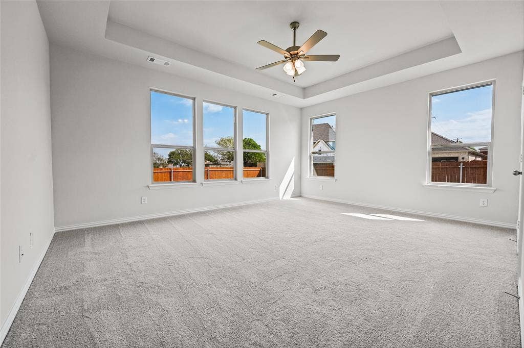 10000 Birchpoint Drive, Fort Worth, TX 76108 Spacious room featuring a tray ceiling, ceiling fan, and light gray carpeting