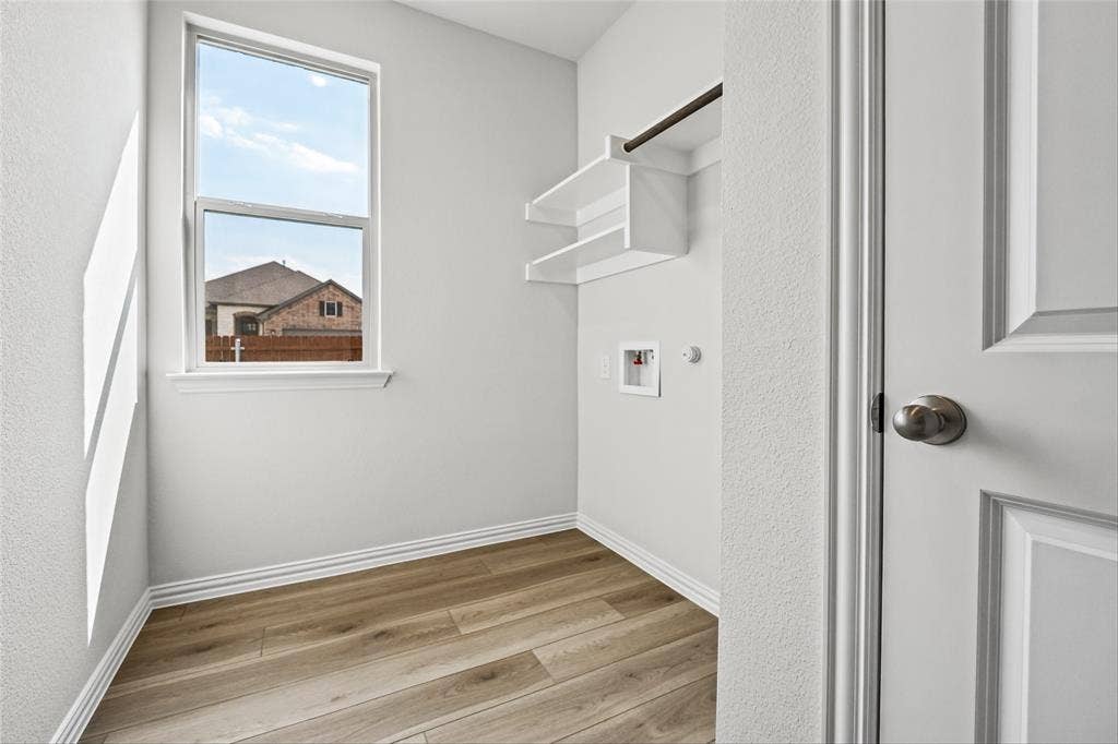 10000 Birchpoint Drive, Fort Worth, TX 76108 Utility area featuring wood-finish flooring, a single window, built-in shelving, and a hanging rod