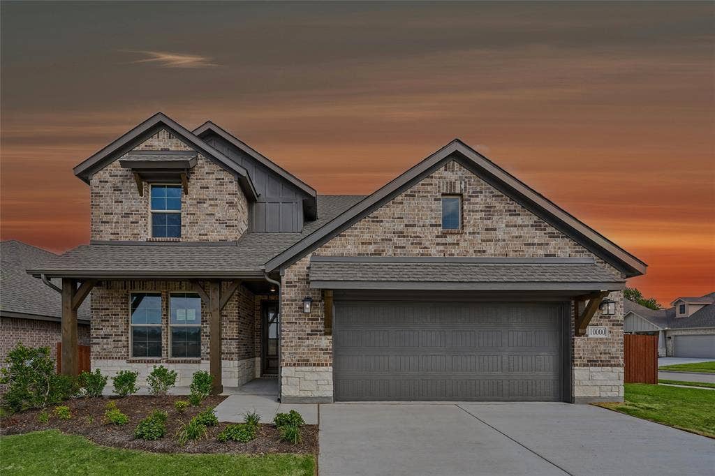 10000 Birchpoint Drive, Fort Worth, TX 76108 Brick and stone exterior with a covered entry, gabled rooflines, and an attached two-car garage