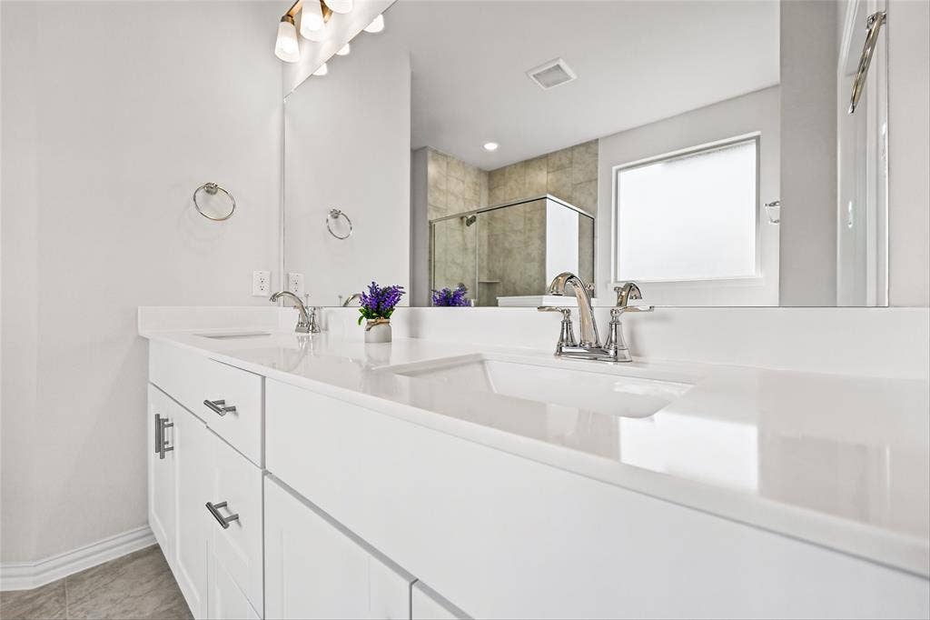 10000 Birchpoint Drive, Fort Worth, TX 76108 Dual vanity with white cabinetry, polished chrome faucets, and integrated rectangular sinks