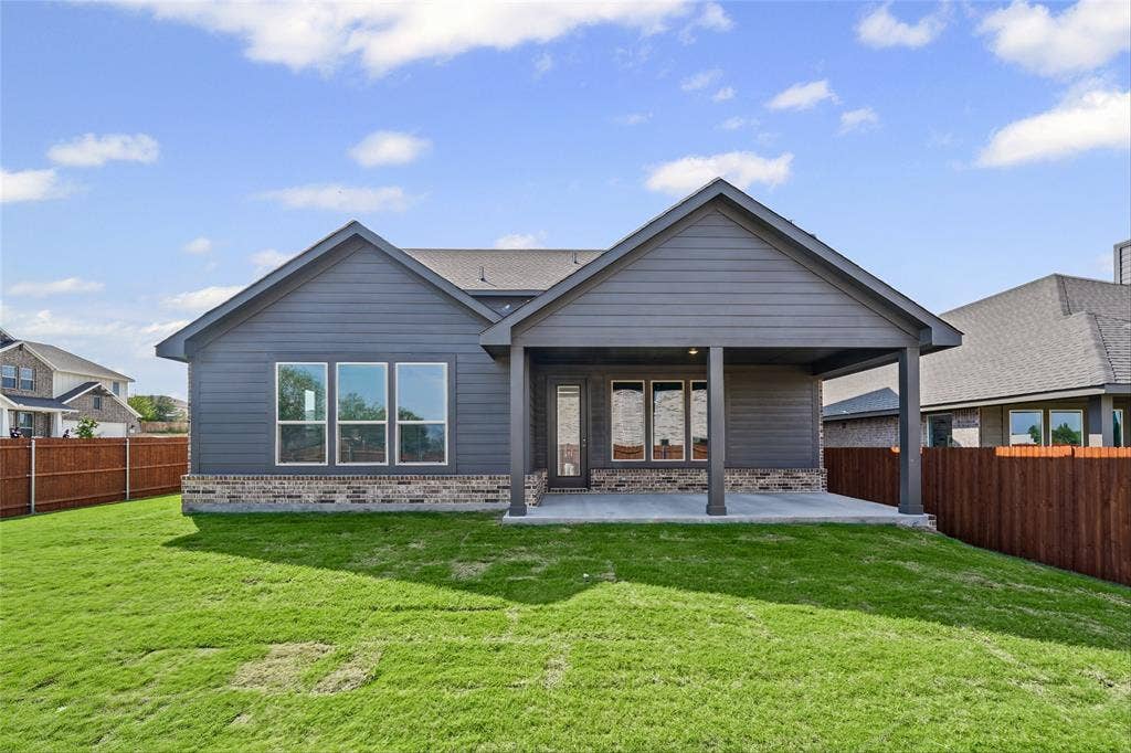 10000 Birchpoint Drive, Fort Worth, TX 76108 Exterior featuring a covered patio, dark gray siding, a shingled roof, a partial brick facade, and multiple windows