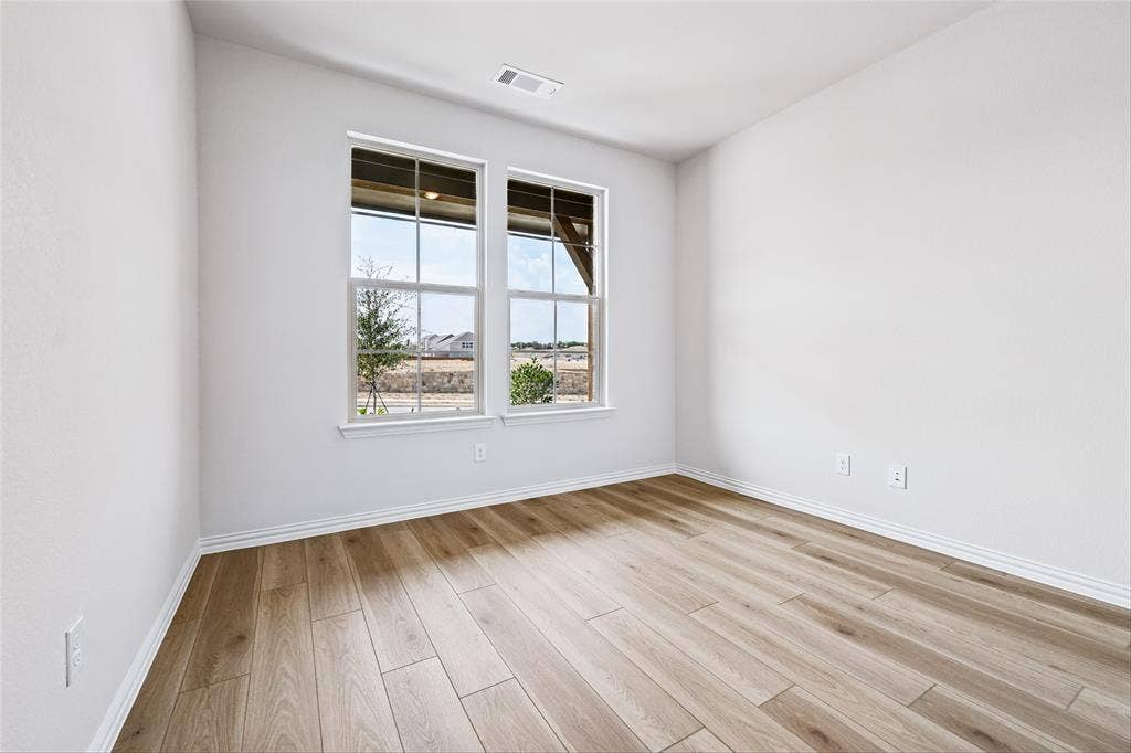 10000 Birchpoint Drive, Fort Worth, TX 76108 Wood-finish flooring, white trim, and a pair of double-pane windows
