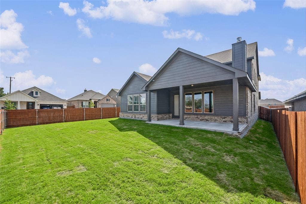 10000 Birchpoint Drive, Fort Worth, TX 76108 Expansive backyard featuring a covered patio, wood fencing, and a sloped lawn