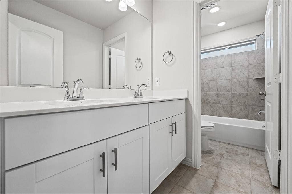10000 Birchpoint Drive, Fort Worth, TX 76108 Dual vanity with white cabinetry and chrome fixtures