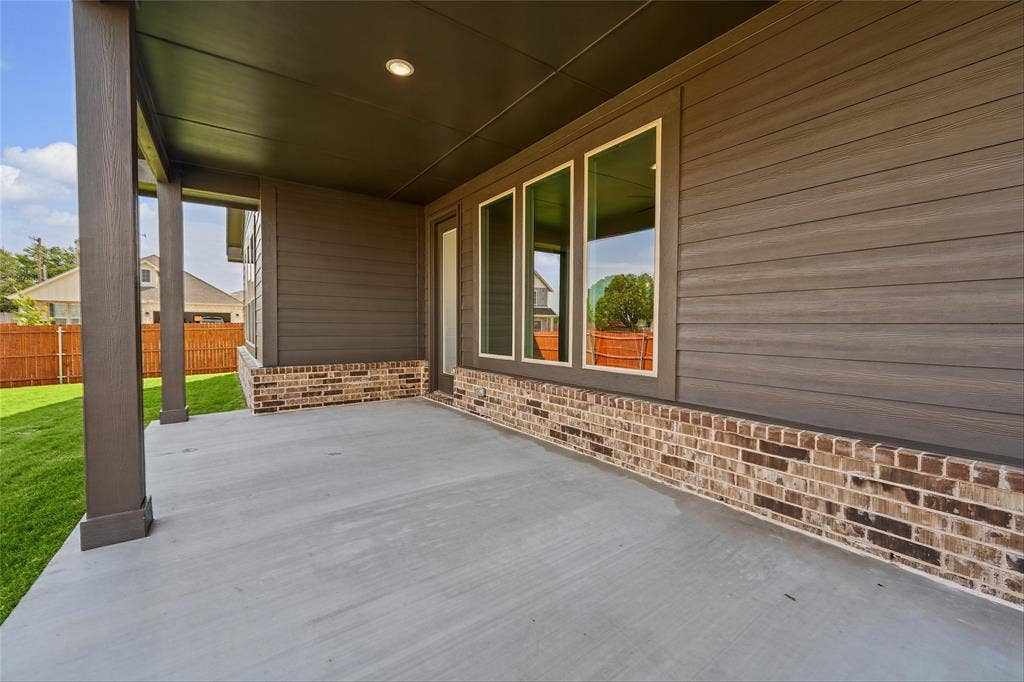 10000 Birchpoint Drive, Fort Worth, TX 76108 Covered concrete patio with recessed lighting, supported by square columns, and a brick and horizontal siding exterior