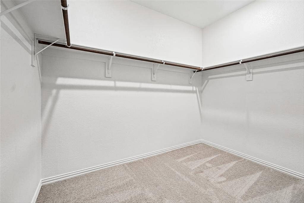 10000 Birchpoint Drive, Fort Worth, TX 76108 L-shaped hanging rods with white shelving brackets, light neutral carpet, and white walls