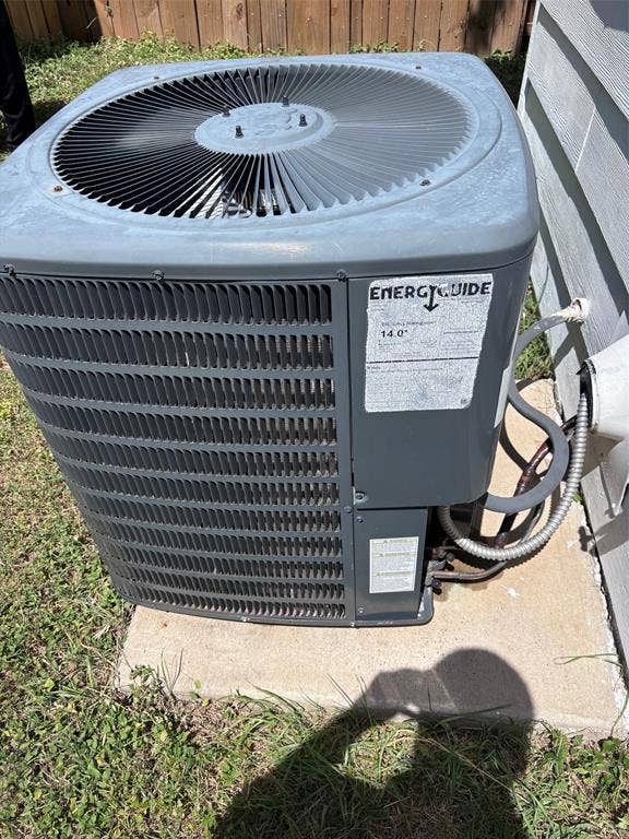 9656 Stonewood Drive, Dallas, TX 75227 Outdoor HVAC unit with visible fan and EnergyGuide label, mounted on a concrete pad
