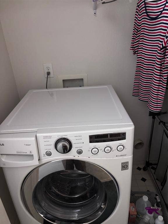 9656 Stonewood Drive, Dallas, TX 75227 Dedicated laundry area featuring a front-loading appliance and wall-mounted electrical outlet