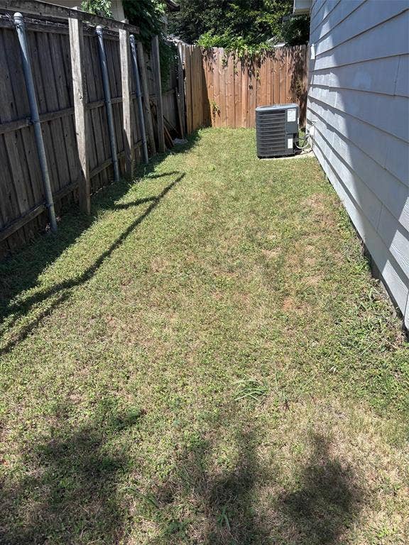 9656 Stonewood Drive, Dallas, TX 75227 Side yard space featuring a wood fence, a second wood-paneled fence, and a central air conditioning unit
